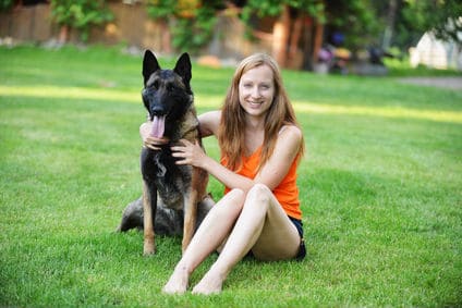 Belgian Malinois and Happy Girl Sitting on Lawn