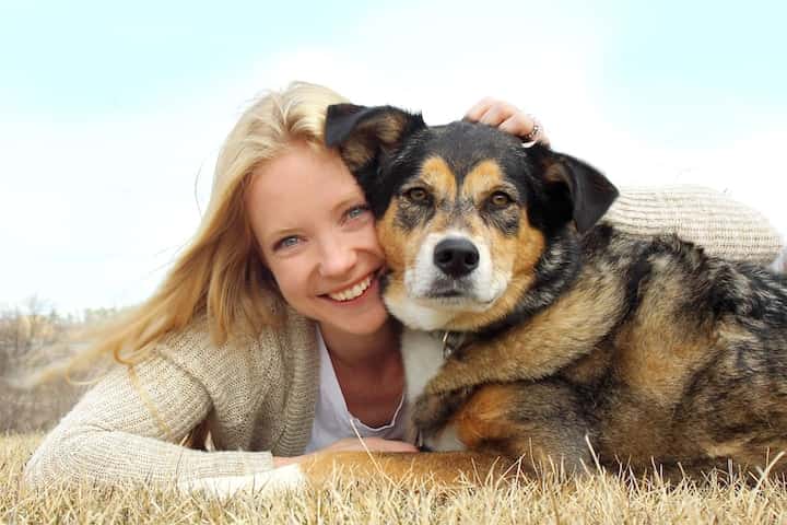Photo of Smiling Woman Lying Down With Dog