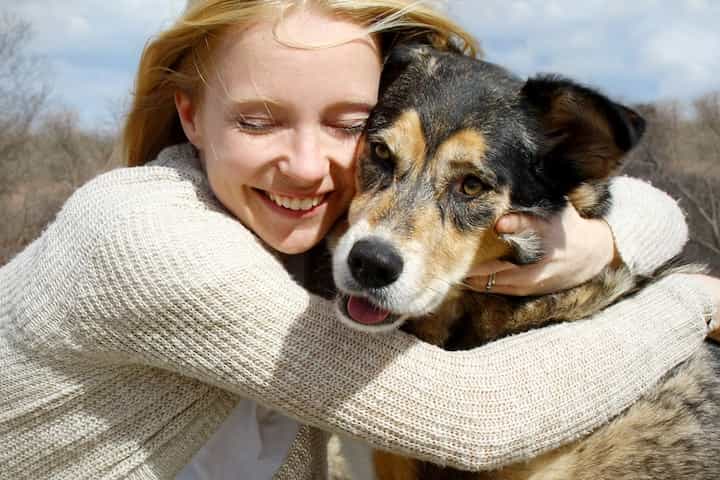 Photo of Woman Lovingly Embarces Her Dog Min