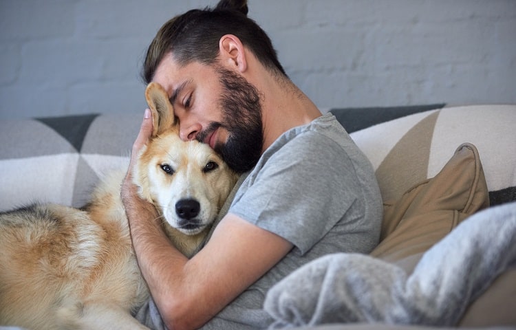 Photo of man hugging his dog