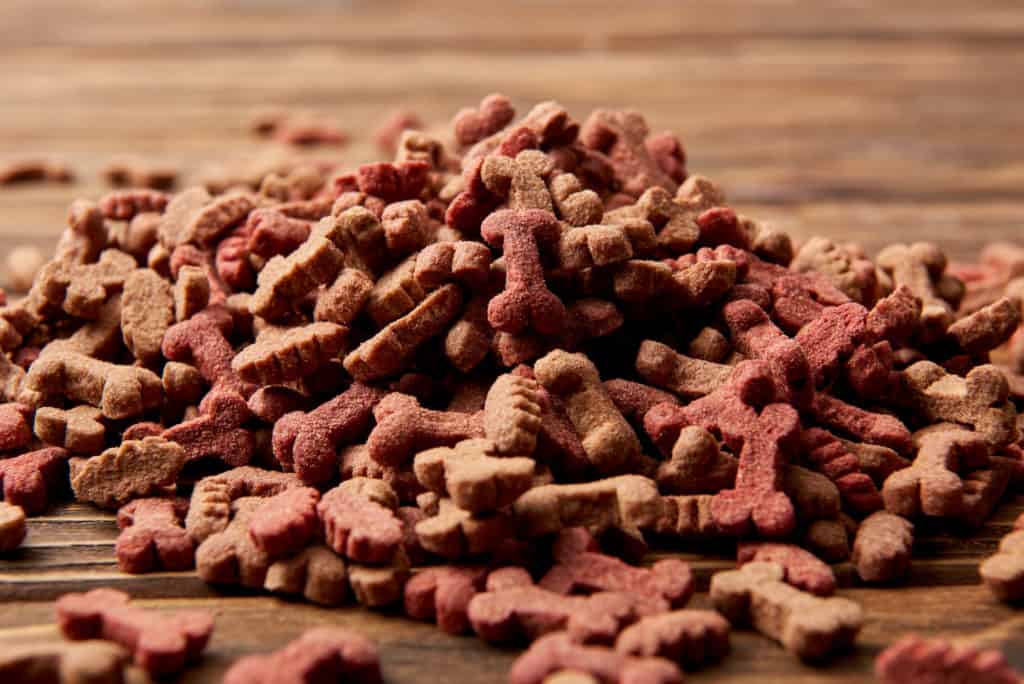 Selective focus of pile of dog food on wooden table 